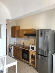 uma cozinha com um frigorífico de aço inoxidável e armários de madeira em Apartamento en La Pared Fuerteventura vista mar em Pájara