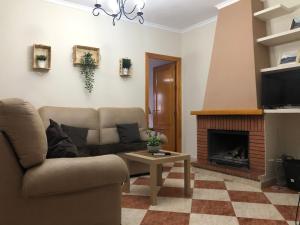 - un salon avec un canapé et une cheminée dans l'établissement Casas PARAJE NATURAL, à Zahara de la Sierra