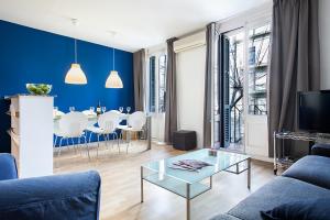 una sala de estar con una pared de acento azul y una mesa en Habitat Apartments Plaza España, en Barcelona