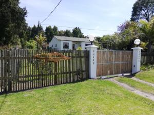 a wooden fence with a gate with a sign on it at Ville Agape in Coldstream