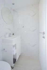 a white bathroom with a sink and a shower at Adriatic Mobile Homes in Sveti Filip i Jakov
