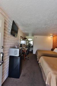 Cette chambre comprend 2 lits et une télévision à écran plat. dans l'établissement Country Inn Beaver Utah, à Beaver