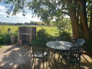 
a patio area with a table, chairs, and a fire place at Lalani B&B/Self catering Cottages in Riversdale
