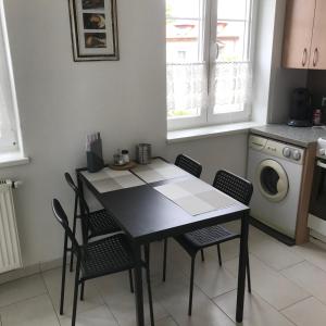 une cuisine avec une table et des chaises ainsi qu'un lave-linge dans l'établissement LG living Apartment, à Stockerau