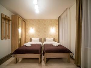 twee bedden in een kleine kamer met twee bedden sidx sidx sidx bij Šarkutė in Palanga