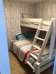 a white bunk bed with a ladder next to a bed at Sea 2 in Middelkerke