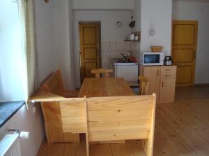 a kitchen with a wooden table and a dining room at Petrovický mlýn in Kasanice