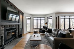 a living room with a couch and a fireplace at Le Chalumeau by Chez Tremblant in Mont-Tremblant