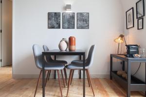 einen Esstisch mit 2 Stühlen und einen Tisch mit einem Schreibtisch in der Unterkunft FLH Intendente Charming Flat in Lissabon