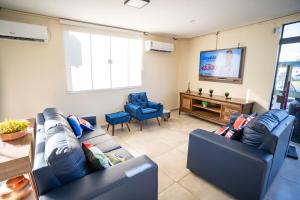 a living room with two couches and a flat screen tv at Shelter Hostel e Pousada in Ponta Porã