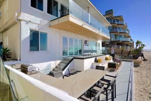 a building on the beach with a table and chairs at Ocean Villas Beach Front in Carlsbad