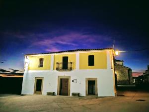 Casa Rural El Fuentarro في Botija: مبنى أبيض مع شرفة فوقه