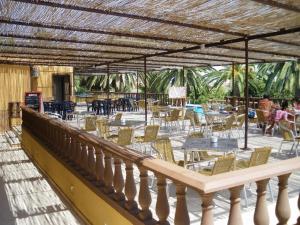 un patio con sillas, mesas, mesas y sillas en Hotel La Barca, en Lepe
