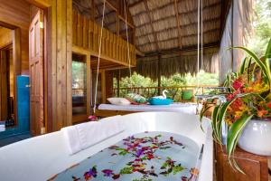 a bath room with a large tub and a large window at Sweet Songs Jungle Lodge in San Ignacio