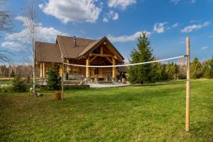 Hlevci的住宿－KRALJICA ŠUME - Divjake Log Home，院子内带排球网的圆木房子