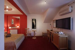 um quarto de hotel com uma cama e uma televisão de ecrã plano em Hotel Millennium em Osijek