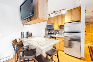 a kitchen with a table and a tv on the wall at Chateau Studio in Breckenridge