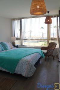 1 dormitorio con cama y ventana grande en Departamento Av del Mar Coquimbo Disegni 03, en Coquimbo