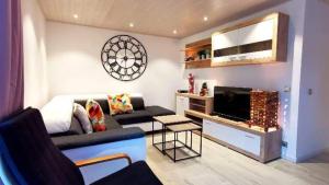 uma sala de estar com um sofá e uma televisão em Le Walker em Francorchamps