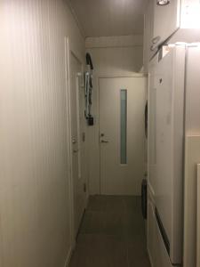 um corredor com um chuveiro e uma porta num quarto em Studio1 em Tromsø