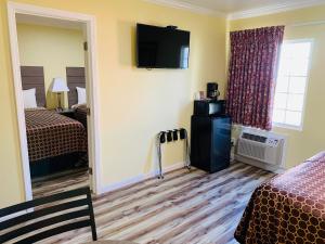 a hotel room with two beds and a television on the wall at Central Coast Inn Cayucos in Cayucos +53 photos