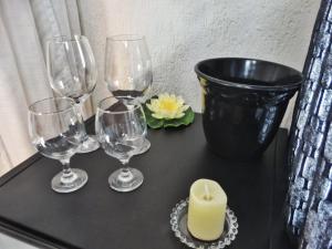 uma mesa com copos de vinho e uma vela em Arraialferias Suites em Arraial do Cabo