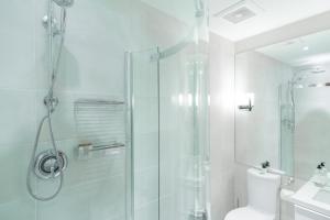 uma casa de banho branca com um chuveiro e um WC. em Northstar by Outpost Whistler em Whistler