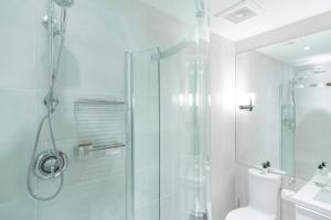 een witte badkamer met een douche en een toilet bij Northstar by Outpost Whistler in Whistler