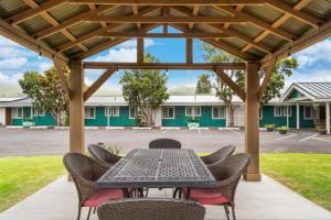 d'une terrasse avec une table et des chaises sous une pergola. dans l'établissement Castle Waimea Country Lodge, à Waimea