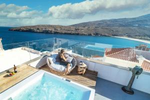 a man sitting in a chair on the deck of a yacht at Castel Abaso Boutique Apartments by Explore Andros in Andros +37 photos