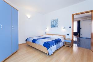 um quarto com uma cama e um espelho grande em Apartments Villa Brioni II em Fažana