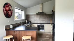 a kitchen with a counter and two stools in it at "Great Scott" Great spot your Tekapo Retreat in Lake Tekapo