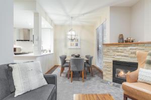 a living room with a table and a fireplace at Northstar by Outpost Whistler in Whistler