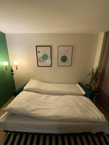 a bed in a bedroom with two pictures on the wall at Forrest Visaginas - Studio apartment in Visaginas