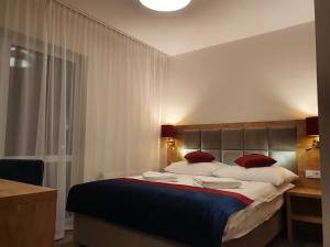 a bedroom with a large bed with red pillows at Villa Roma przy wyciągu na Szrenicę in Szklarska Poręba