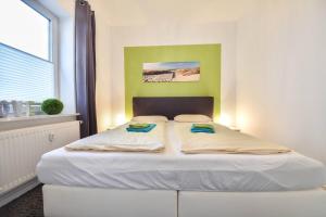 Ce lit se trouve dans un dortoir doté d'un mur vert. dans l'établissement Villen am Buchenpark 17, à Heringsdorf