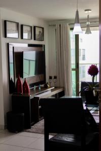 a living room with a desk with a large mirror at Apartamento Jussara Freitas 2 quartos in Recife