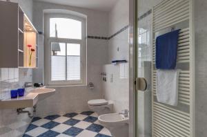 a white bathroom with a toilet and a sink at Hotel Aquamarin in Kühlungsborn