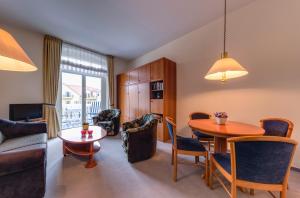 a living room with a table and a dining room at Hotel Aquamarin in Kühlungsborn