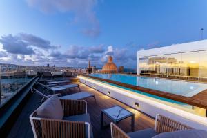 a rooftop deck with a swimming pool on a building at The Embassy Valletta Hotel in Valletta