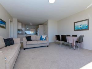 Shoalhaven 4 28 Voyager Cl - waterfront unit with stunning views and Wifi في خليج نيلسون: غرفة معيشة بها أريكة وطاولة