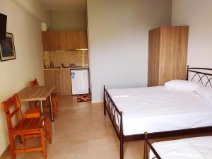 a bedroom with a bed and a table and a kitchen at Zacharogianni Studios in Nikiana