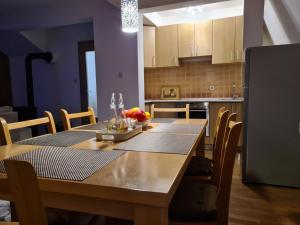 a kitchen with a wooden table and a kitchen with a refrigerator at KUĆA NENO in Vlasic