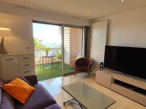 a living room with a couch and a flat screen tv at Classy Apartment in Nice with pool and private parking place in Nice