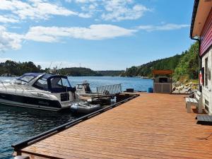 a boat is docked at a dock on a lake at 4 person holiday home in Urangsv g in Ervik