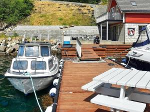 a boat is docked at a dock in the water at 4 person holiday home in Urangsv g in Ervik