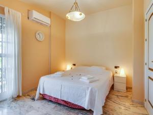 a bedroom with a white bed and a clock on the wall at Belvilla by OYO Casa de Rudi in Seville