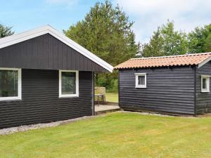 uma casa preta e um barracão com um quintal em 6 person holiday home in Toftlund em Toftlund