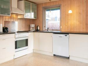 uma cozinha com electrodomésticos brancos e paredes de madeira em 6 person holiday home in Toftlund em Toftlund