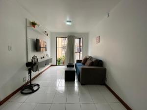 uma sala de estar com um sofá e uma janela em Charme Barra Mar em São Luís